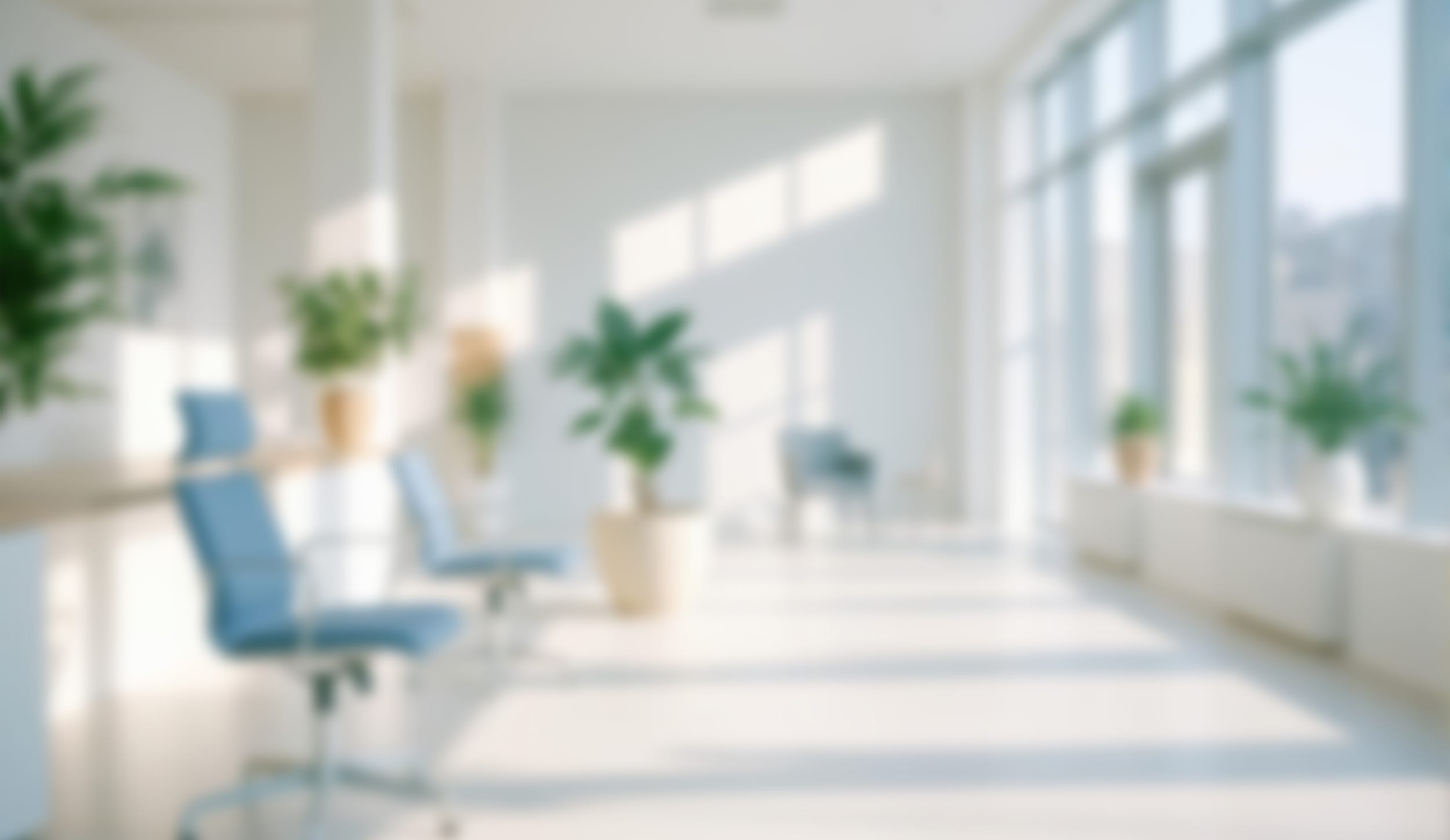 Bright, softly blurred clinic corridor with tall windows and plants