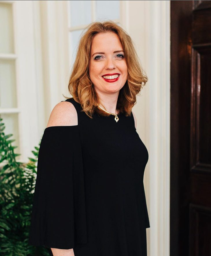 Laura Schultheis, front office manager, in a black dress at the practice