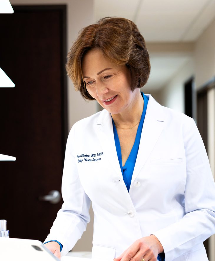 Dr. Anna Wooten, board certified plastic surgeon, in a white coat at the practice