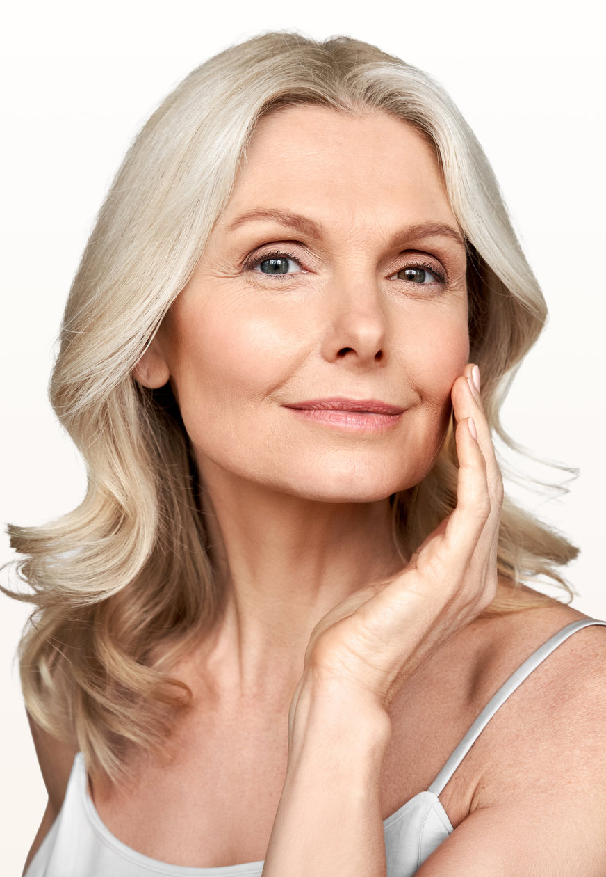Mature woman with silver-blonde hair and a smooth, relaxed forehead touching her cheek